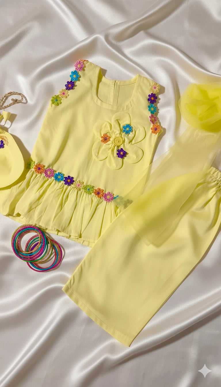 Yellow children's outfit with floral embellishments on a white fabric background